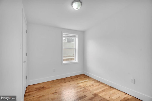 unfurnished room with baseboards and light wood finished floors