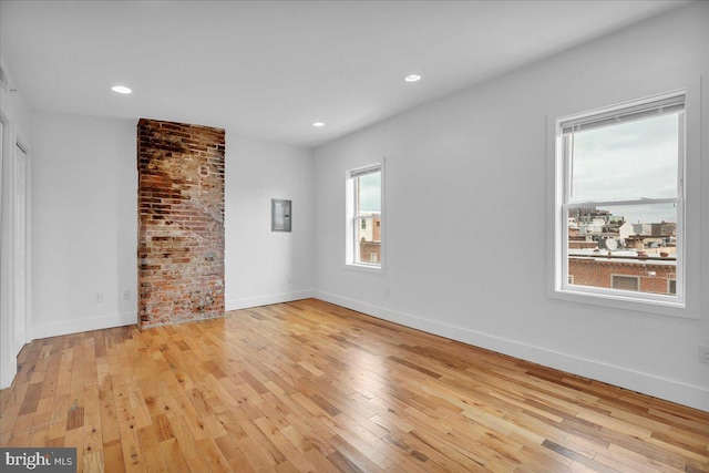 unfurnished room featuring light wood finished floors, recessed lighting, and baseboards