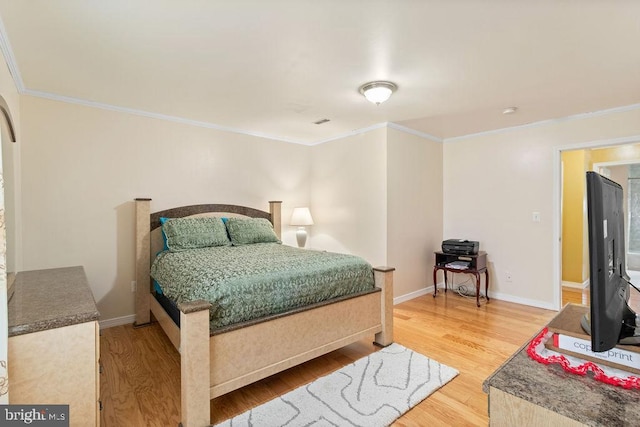 bedroom with crown molding, baseboards, and wood finished floors