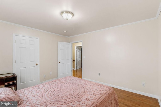 bedroom with baseboards, wood finished floors, and ornamental molding