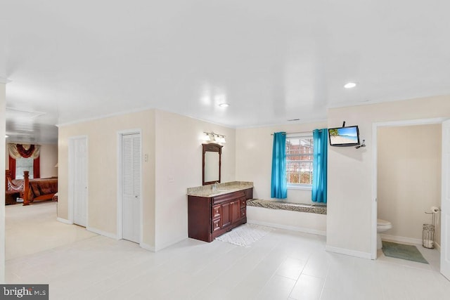 ensuite bathroom with baseboards, toilet, ensuite bath, vanity, and recessed lighting