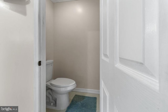 bathroom featuring toilet and baseboards