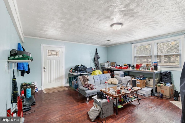 interior space featuring crown molding, a textured ceiling, baseboards, and wood finished floors