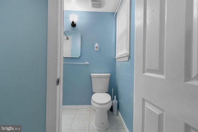 bathroom with baseboards, toilet, and tile patterned floors