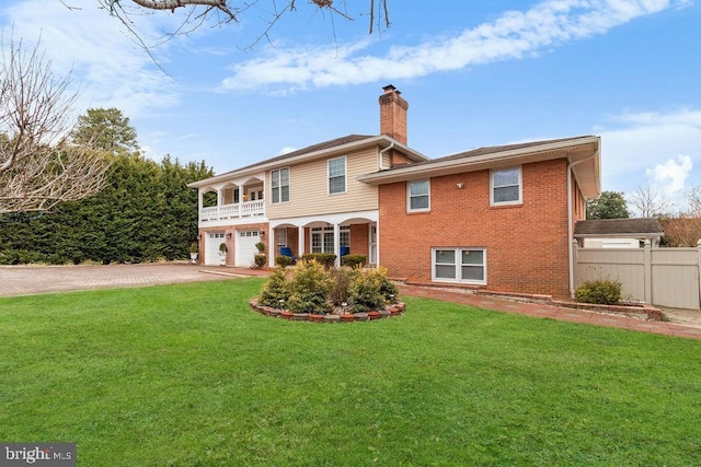 back of property with driveway, a garage, a lawn, and brick siding