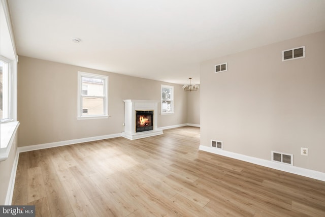 unfurnished living room featuring light wood-style floors and visible vents