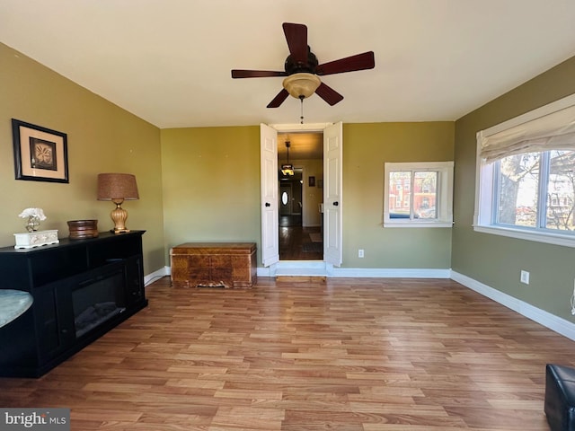 interior space with light wood-style floors, ceiling fan, and baseboards