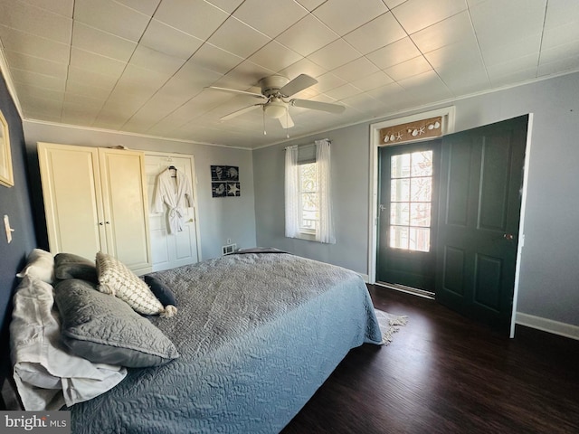 bedroom featuring baseboards, ceiling fan, dark wood-type flooring, and crown molding