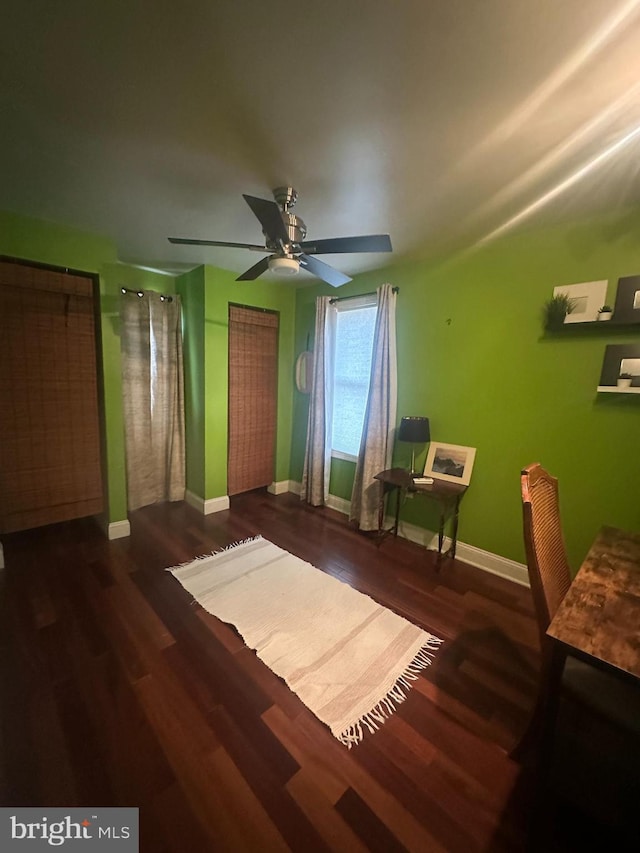 bedroom featuring dark wood finished floors, baseboards, and ceiling fan