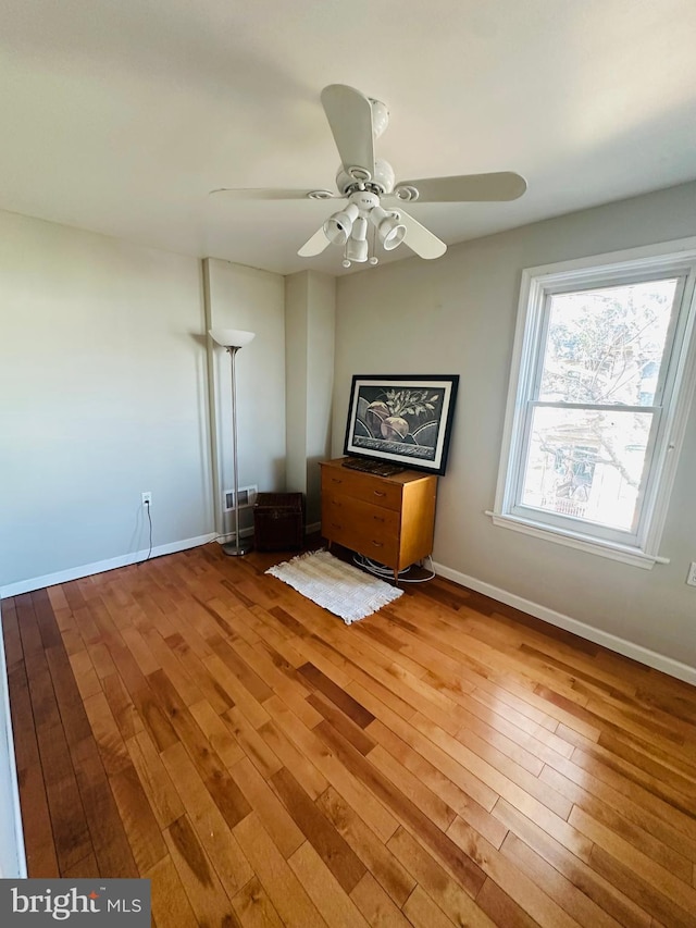 spare room with a ceiling fan, baseboards, and wood finished floors