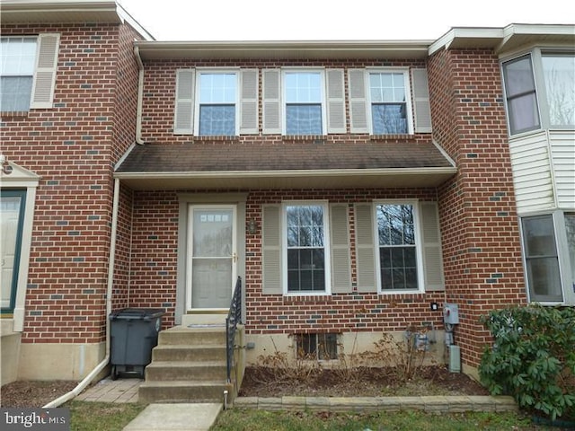 townhome / multi-family property featuring entry steps and brick siding