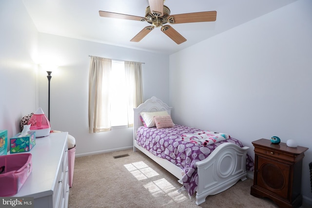 bedroom with a ceiling fan, visible vents, light carpet, and baseboards