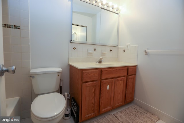 bathroom featuring toilet, tile patterned flooring, decorative backsplash, and vanity