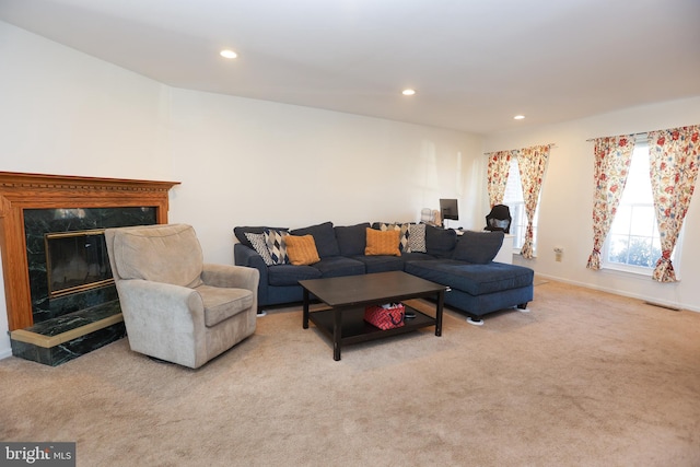 living room with baseboards, light colored carpet, a high end fireplace, and recessed lighting