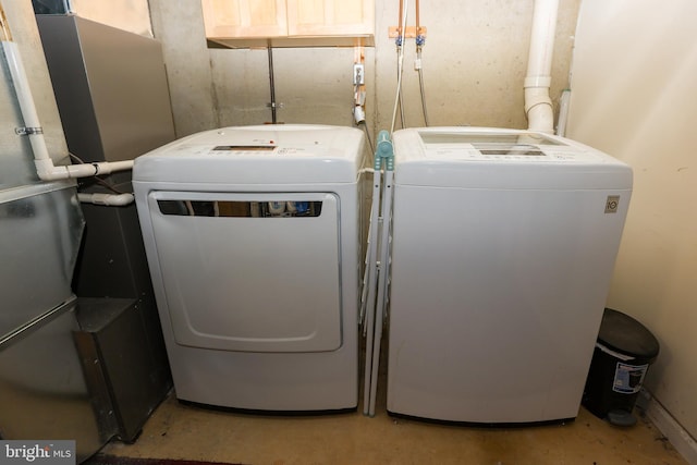 clothes washing area with heating unit, laundry area, and separate washer and dryer