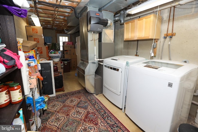 washroom featuring laundry area, washing machine and clothes dryer, and heating unit