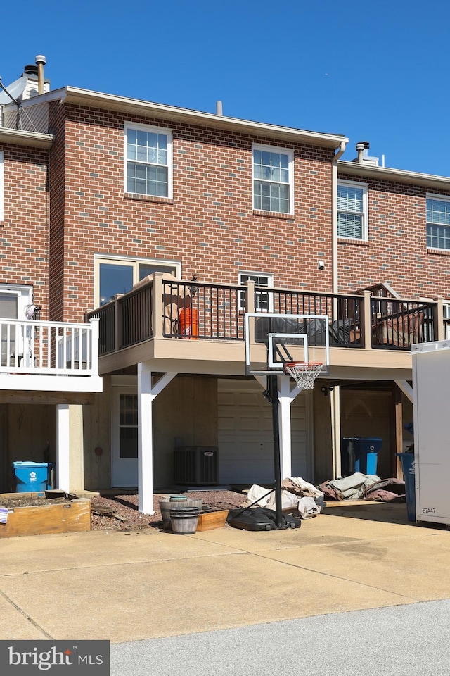 back of house with concrete driveway and brick siding