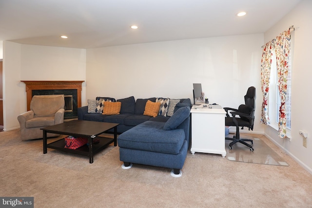 living area featuring a high end fireplace, recessed lighting, and carpet