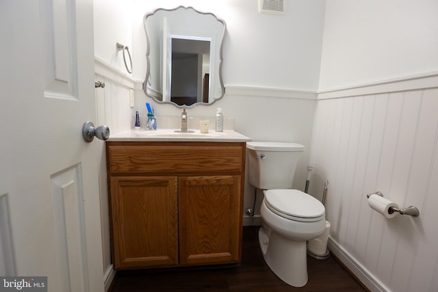 bathroom featuring wainscoting, visible vents, vanity, and toilet