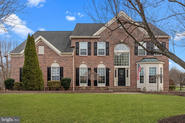 colonial house with brick siding, roof with shingles, and a front lawn