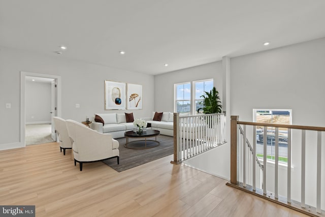 living room with baseboards, light wood-type flooring, and recessed lighting