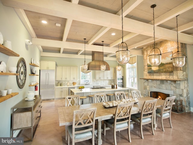 dining area with recessed lighting, a fireplace, beam ceiling, and finished concrete floors