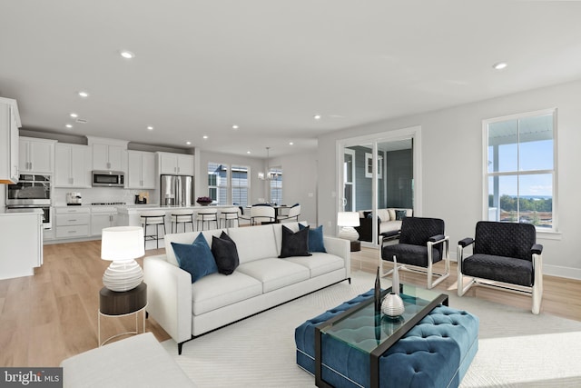 living room featuring baseboards, light wood-type flooring, and recessed lighting