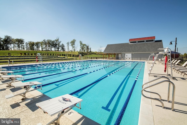 pool with a patio area and fence