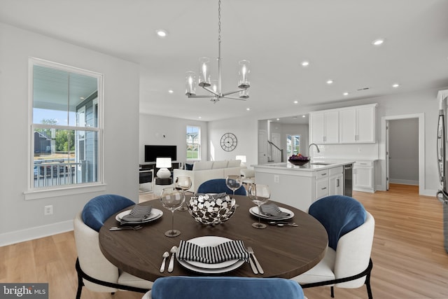 dining space with light wood-style floors, recessed lighting, a wealth of natural light, and a notable chandelier