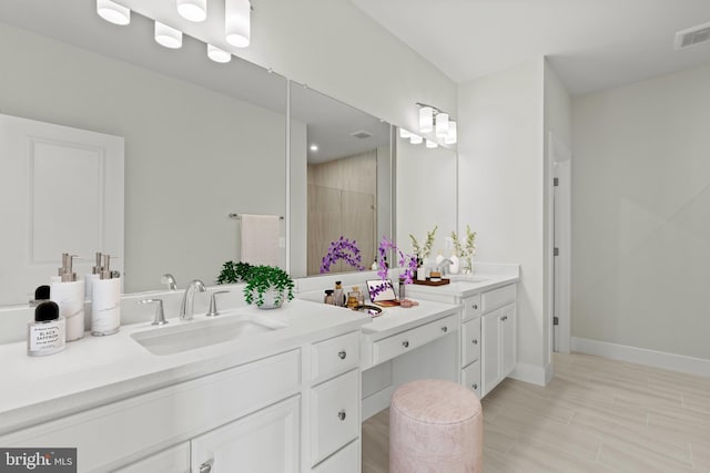 bathroom featuring visible vents, vanity, and baseboards