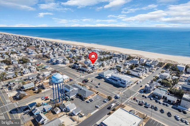 birds eye view of property with a water view and a beach view