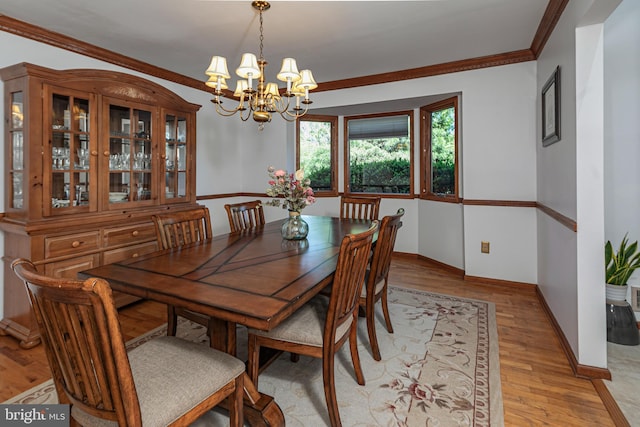 dining area featuring a chandelier, light wood-type flooring, baseboards, and ornamental molding