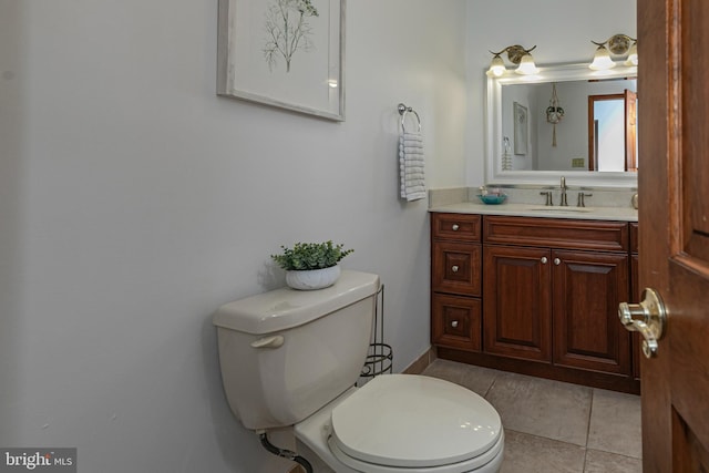 half bath with toilet, vanity, and tile patterned flooring