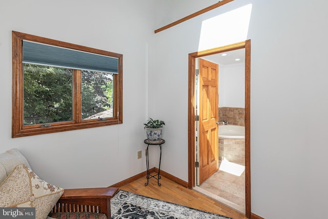 living area featuring baseboards and light wood-style flooring
