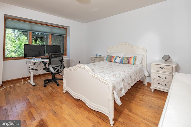 bedroom with light wood finished floors and baseboards