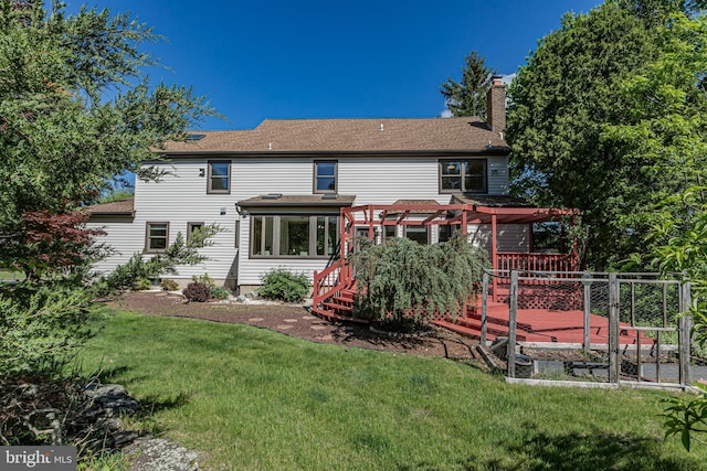rear view of house with a pergola, a deck, a chimney, a lawn, and a shingled roof