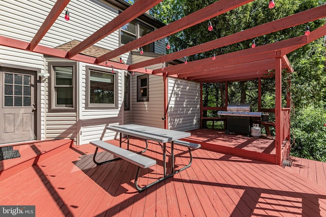wooden deck with outdoor dining area, a pergola, and a grill