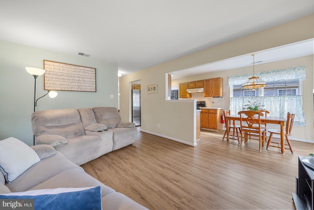 living room featuring baseboards, visible vents, and light wood-style floors