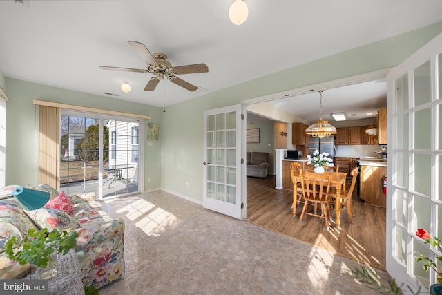 living room featuring ceiling fan, visible vents, baseboards, and french doors