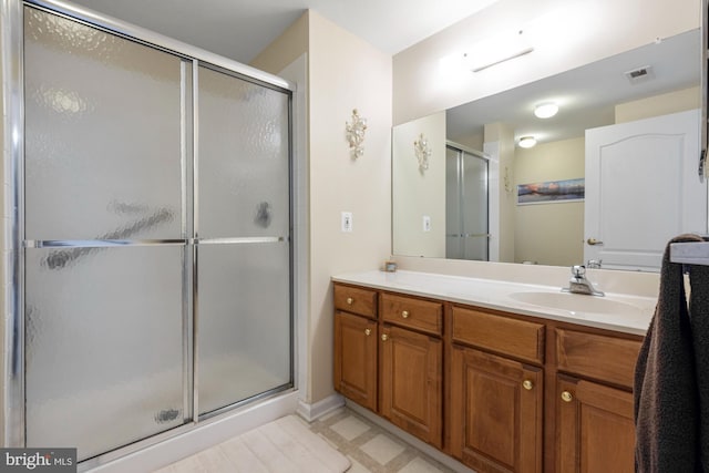 bathroom with visible vents, a shower stall, and vanity