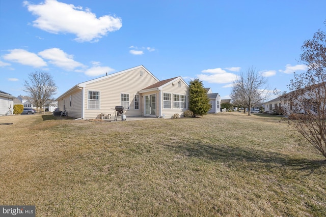 back of house with a lawn and a patio