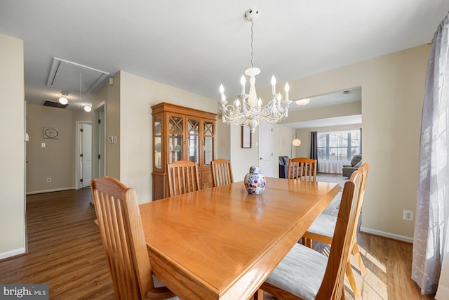 dining area featuring attic access, visible vents, baseboards, and wood finished floors