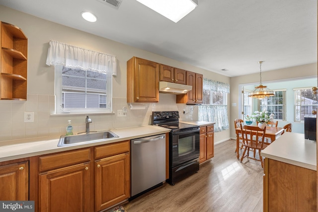 kitchen featuring light wood-style floors, dishwasher, black range with electric stovetop, under cabinet range hood, and a sink