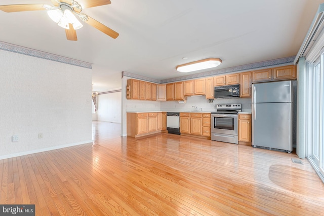 kitchen featuring a ceiling fan, appliances with stainless steel finishes, light wood finished floors, baseboards, and light countertops