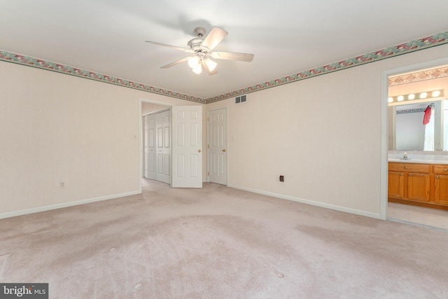 spare room featuring ceiling fan, light colored carpet, visible vents, and baseboards