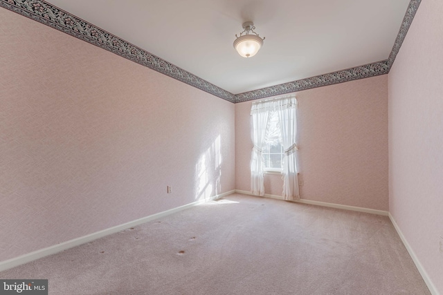 unfurnished room with baseboards and carpet