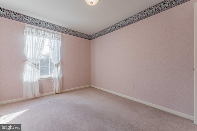 carpeted empty room with baseboards