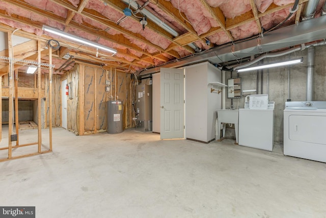 unfinished basement with water heater, washer and dryer, electric water heater, and a sink