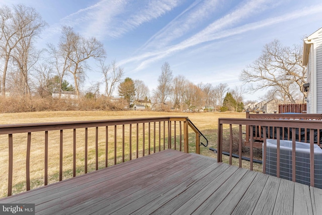 deck featuring cooling unit and a yard