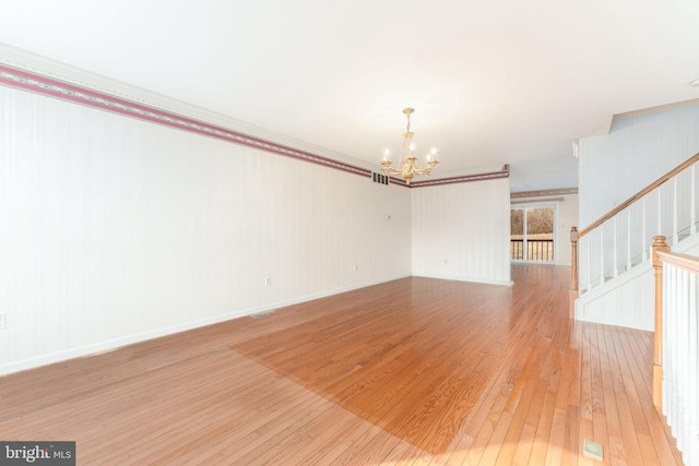 unfurnished room with visible vents, baseboards, stairs, light wood-style floors, and a notable chandelier